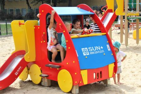 Dzieci bawiące sie w drewnianym samochodziku