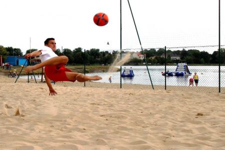 Zawodnik kopiący piłkę do beach soccera