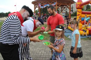 Uczestnicy pikniku bawią się z mimem